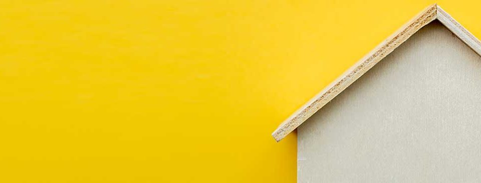 imatge decorativa amb casa de fusta amb fons groc - Nucli Solar